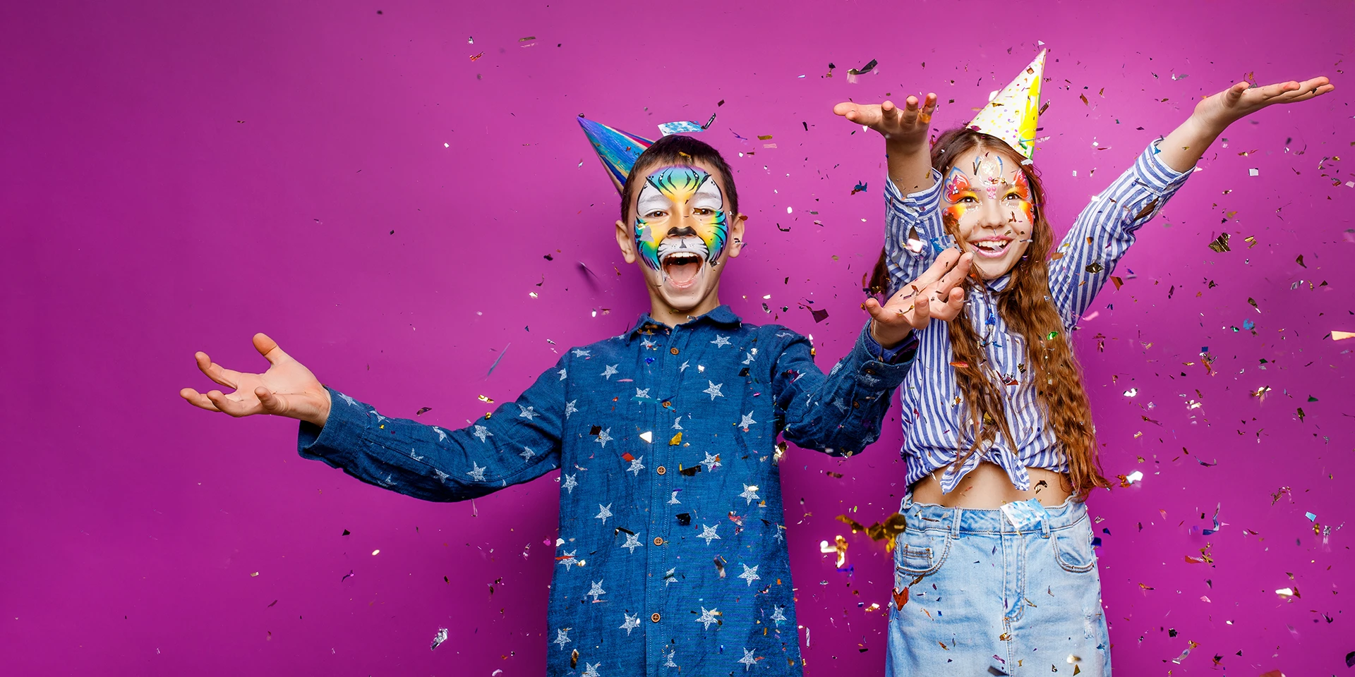 Two children celebrating with confetti and party hats